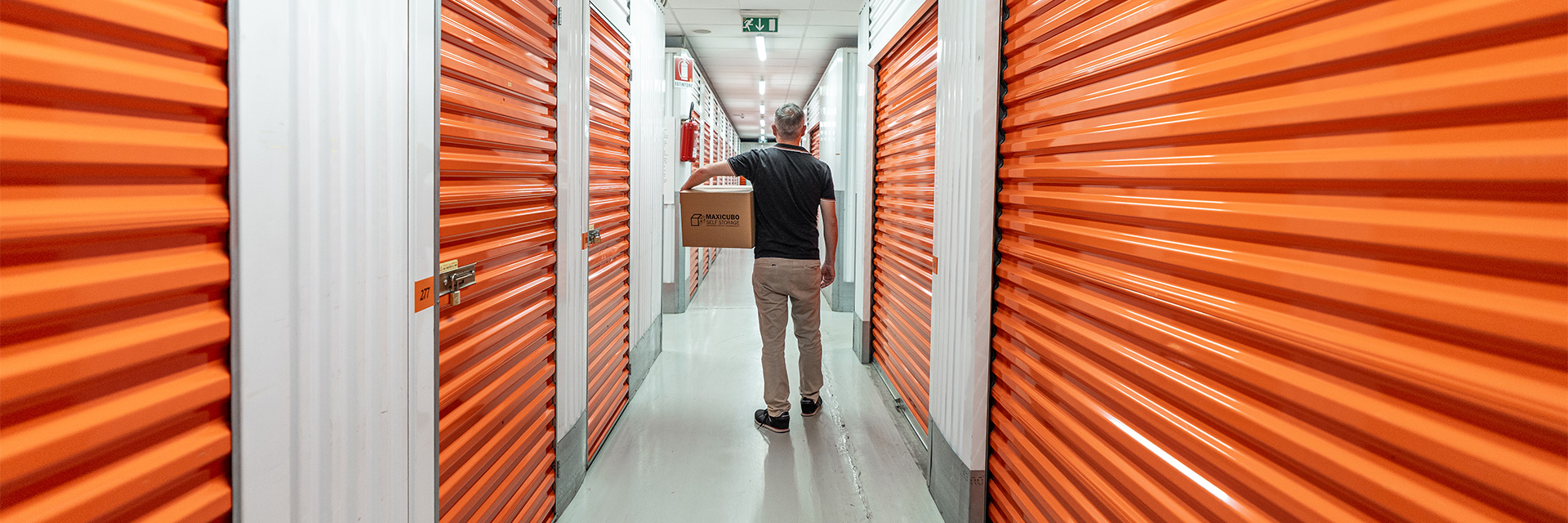 Persona con Scatolone in Mano cammina fra i Corridoi di Maxicubo Self Storage