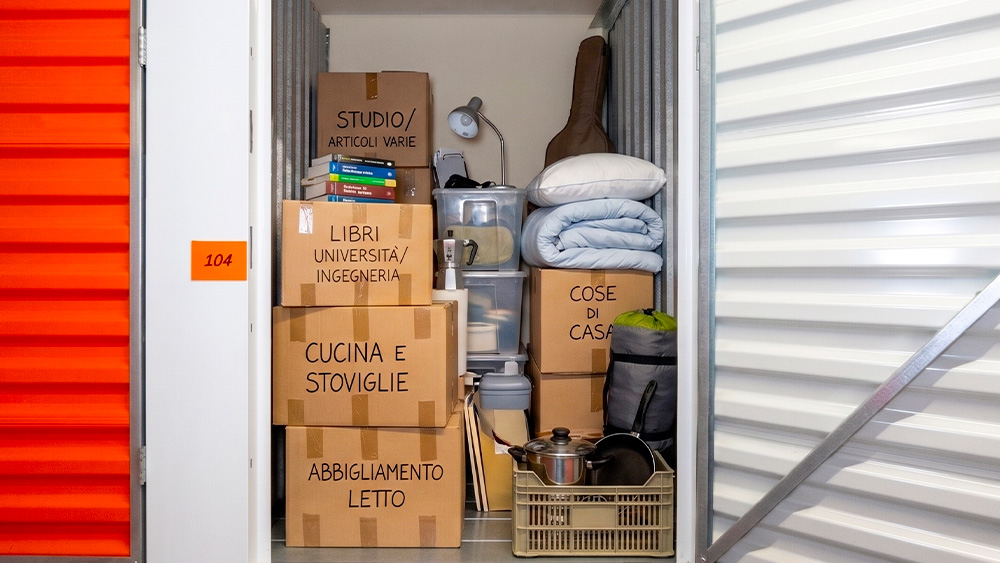 Locker con inseriti Scatoloni di Libri, Coperte, Lampada, Chiatarra, Pentole, Caffetteria e Altro